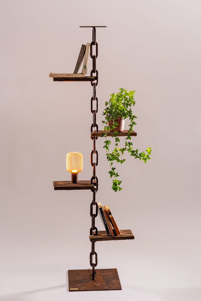 Scaffale luminoso con quattro ripiani portavasi o libri, lampadina decorativa e pianta ornamentale; struttura in catena metallica e legno bruciato