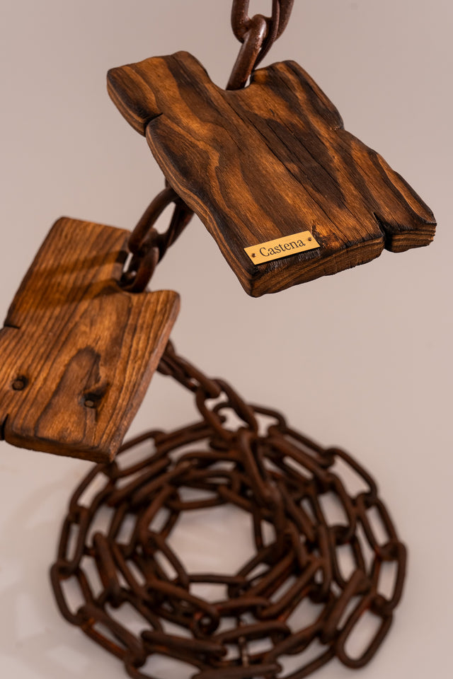 Dettaglio dei ripiani in legno marino della lampada Scilla, con catena arrugginita a spirale e base stabile intrecciata