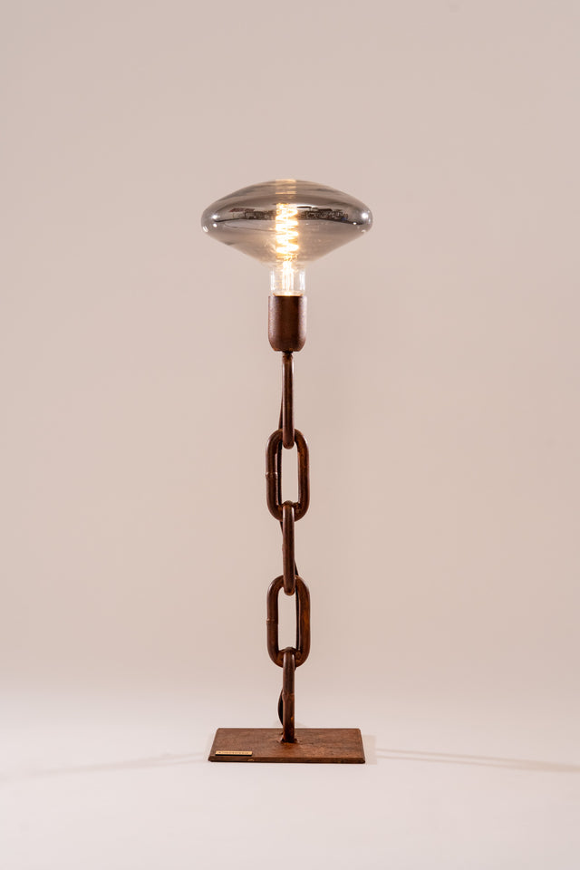 Lampada Idra da tavolo con catena navale verticale e lampadina LED fumé, stile industriale con base in metallo ossidato