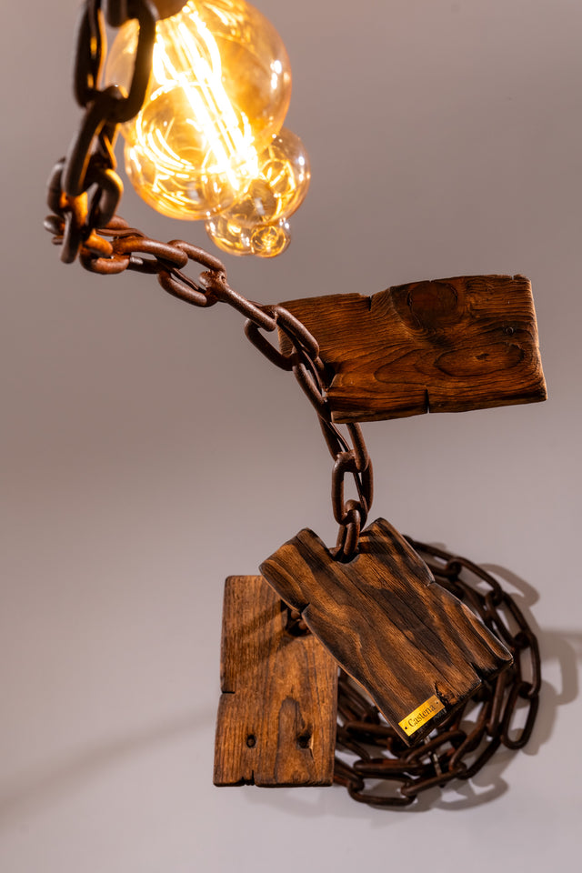 Ripresa ravvicinata dei ripiani in legno massiccio e del punto di innesto con la catena, con luce accesa e marchio Castena in evidenza